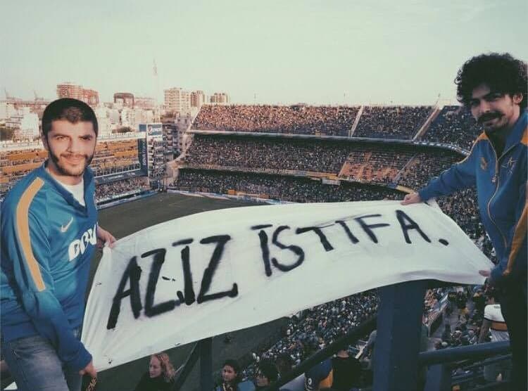 İki taraftar AZİZ İSTİFA pankartı tutuyor