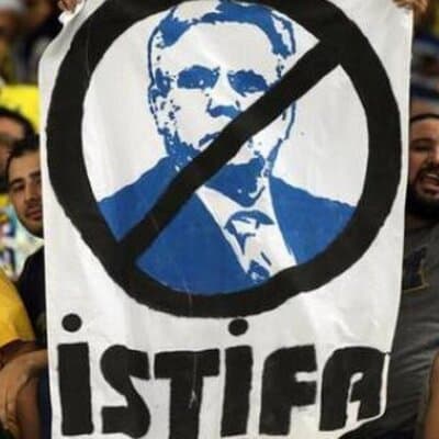 Aziz Yıldırım istifa pankartı — yasak işareti içinde mavi portre ve İSTİFA yazısı